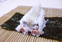 ほっぺの間に20gのご飯を補い、その上に、先に作った白の細巻きを置き、間と両端に10gづつおぎなう。次にてっぺんに30gの白のすし飯を山の形に置きます。
