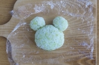 15gのご飯に、焼いたサラダスパゲッティを刺して、大きなおにぎりに固定させます。カエルの目の位置になるように合わせて下さい。