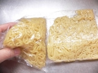 左の麺が、袋のまま電子レンジに入れ、600Wで、1袋につき1分弱加熱してほぐしたもの。バラバラにほぐれている。<br />
<br />
右が加熱する前の蒸し中華麺で、平らなまま固まっている。<br />